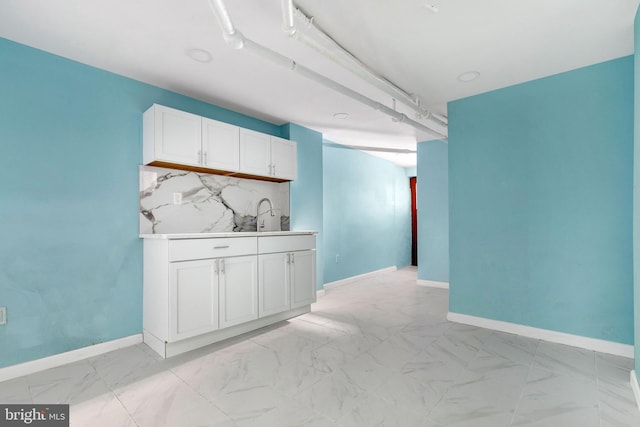 kitchen featuring decorative backsplash and white cabinetry