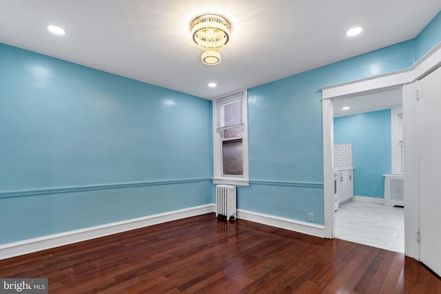 spare room with radiator heating unit and hardwood / wood-style floors