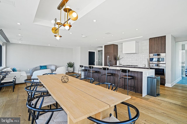 dining room with light hardwood / wood-style floors and sink