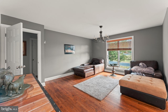 living room featuring baseboard heating, hardwood / wood-style floors, and a chandelier