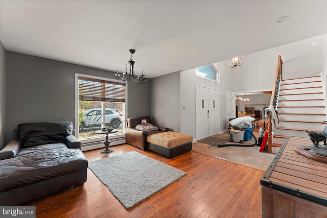 living room featuring a chandelier, a baseboard heating unit, and hardwood / wood-style flooring