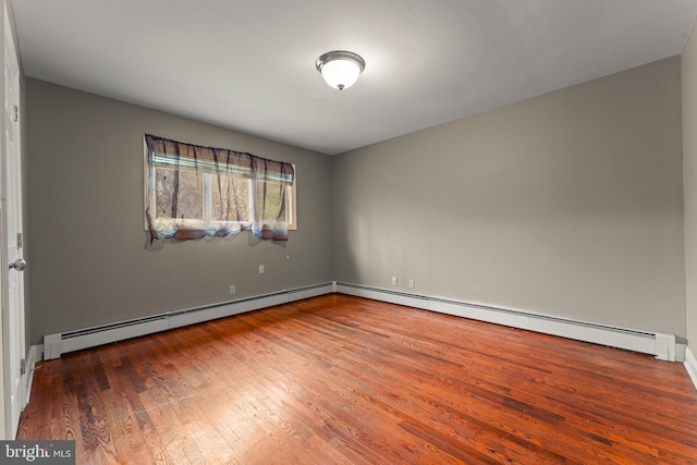 spare room with hardwood / wood-style floors and baseboard heating