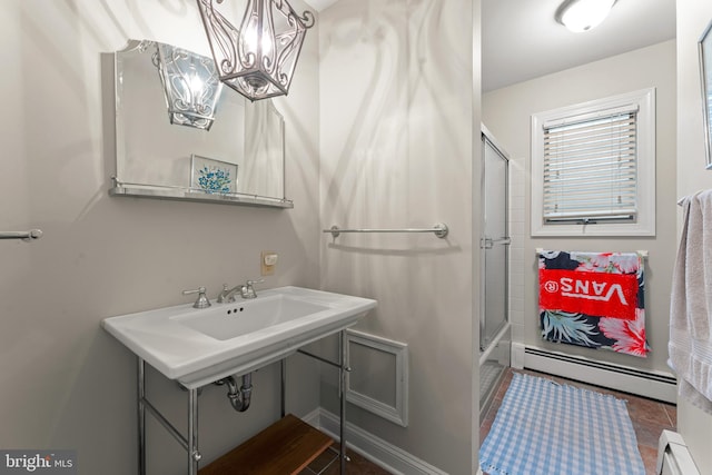 bathroom featuring shower / bath combination with glass door, tile patterned flooring, and a baseboard heating unit