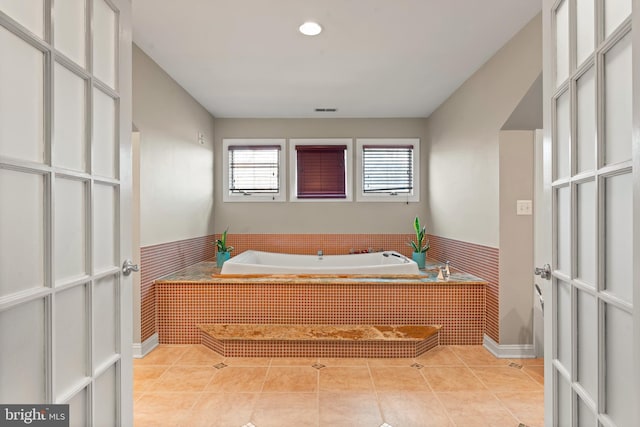 bathroom featuring tile patterned floors and tiled bath