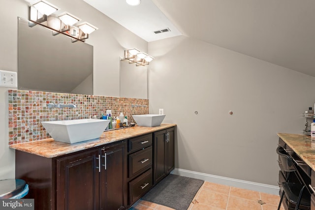 bathroom with tile patterned flooring, vanity, tasteful backsplash, and lofted ceiling