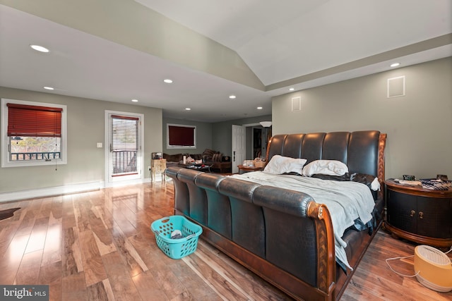 bedroom featuring hardwood / wood-style floors, lofted ceiling, and baseboard heating