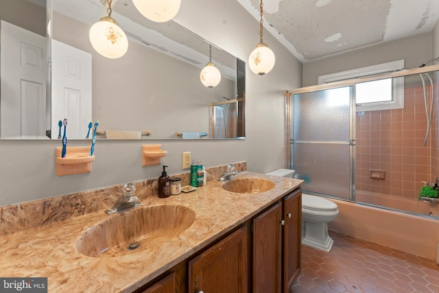 full bathroom featuring shower / bath combination with glass door, vanity, tile patterned floors, and toilet