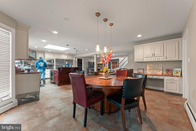 dining room featuring a skylight, beverage cooler, and a baseboard heating unit