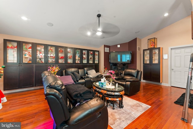 living room featuring hardwood / wood-style floors, vaulted ceiling, and ceiling fan