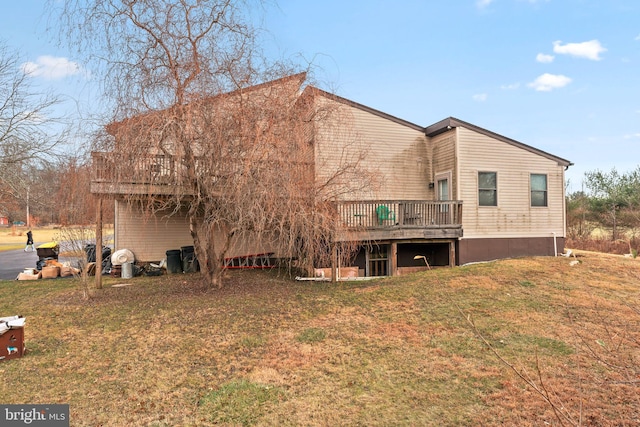 rear view of house featuring a lawn and a deck