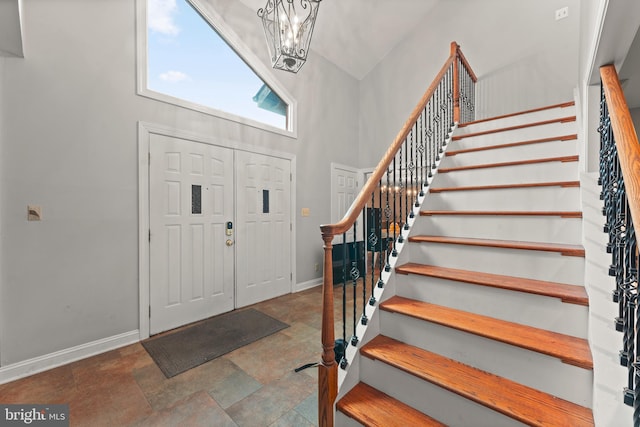 entryway with a high ceiling and a chandelier