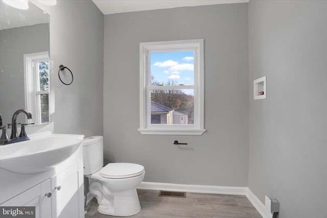 bathroom with vanity, wood-type flooring, and toilet