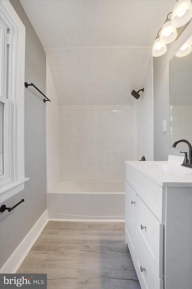 bathroom featuring vanity, wood-type flooring, and tiled shower / bath