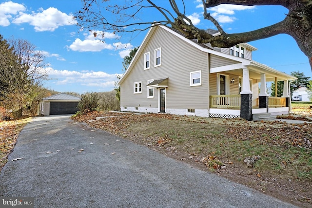 view of side of home featuring an outbuilding, a porch, and a garage