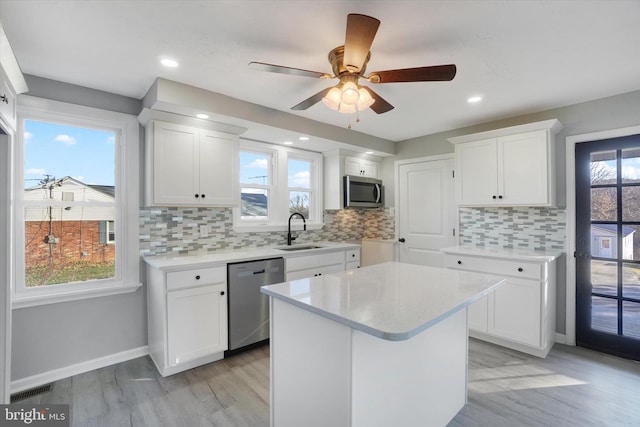 kitchen with backsplash, ceiling fan, white cabinets, and appliances with stainless steel finishes