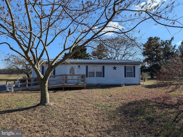 view of front of property with a front yard and a deck