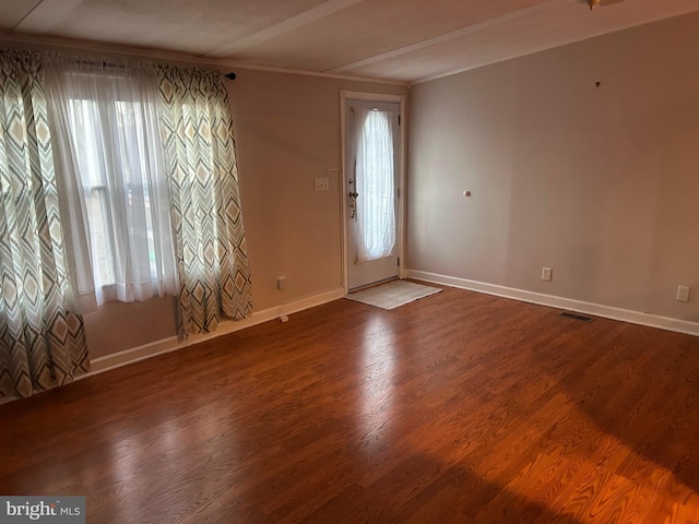 foyer featuring hardwood / wood-style floors, a healthy amount of sunlight, and ornamental molding