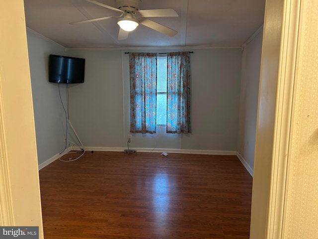 empty room with ornamental molding, ceiling fan, and dark wood-type flooring