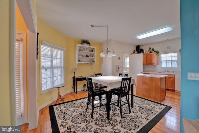 dining area with a chandelier, light hardwood / wood-style floors, and plenty of natural light