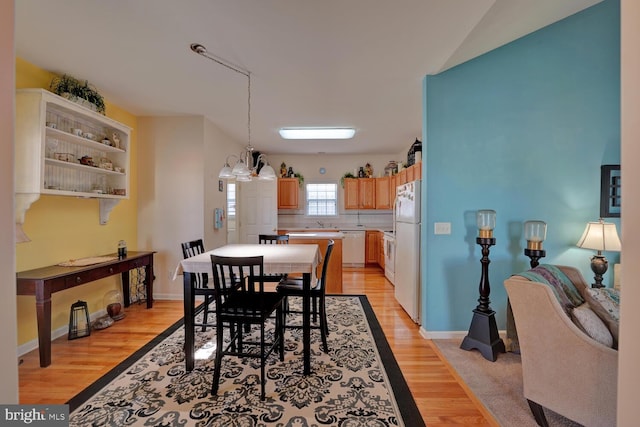 dining area with a notable chandelier and light hardwood / wood-style floors