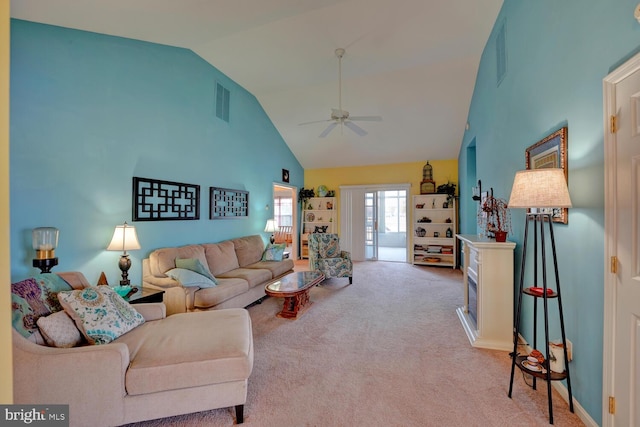 carpeted living room with ceiling fan and high vaulted ceiling