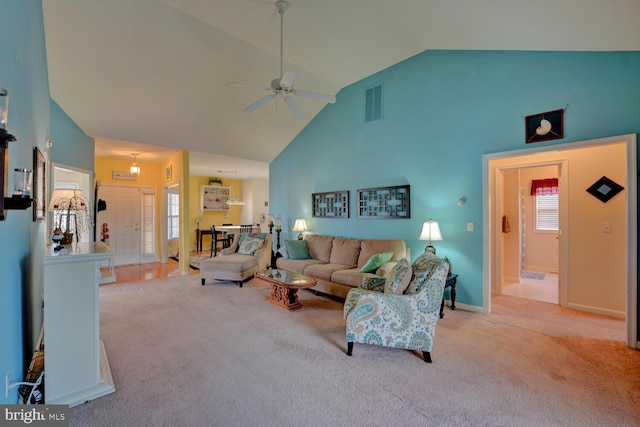 carpeted living room with ceiling fan and high vaulted ceiling