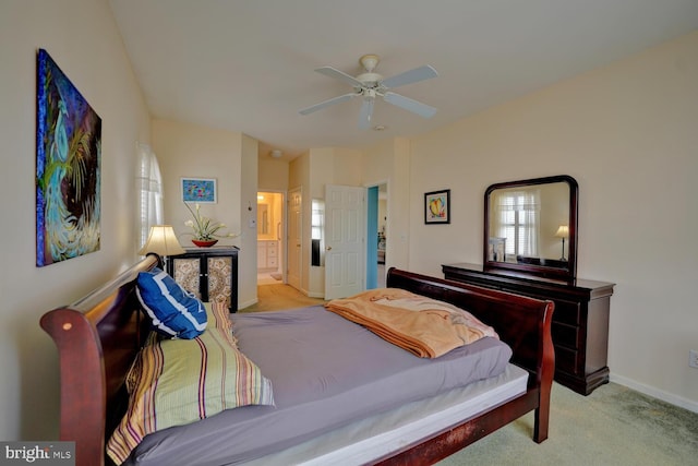 bedroom with connected bathroom, light colored carpet, and ceiling fan