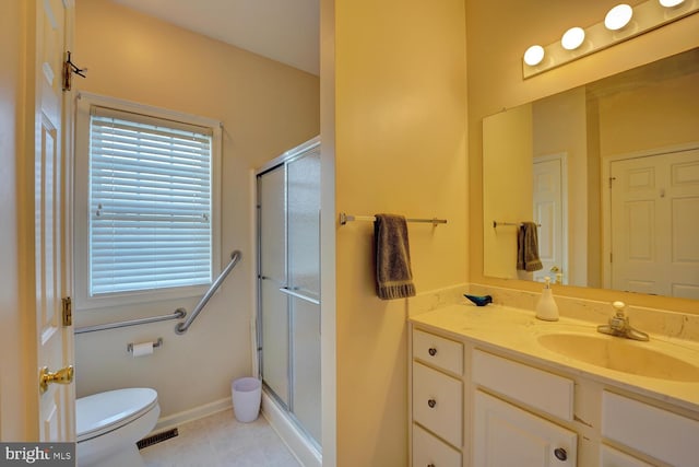 bathroom with tile patterned flooring, vanity, toilet, and a shower with shower door