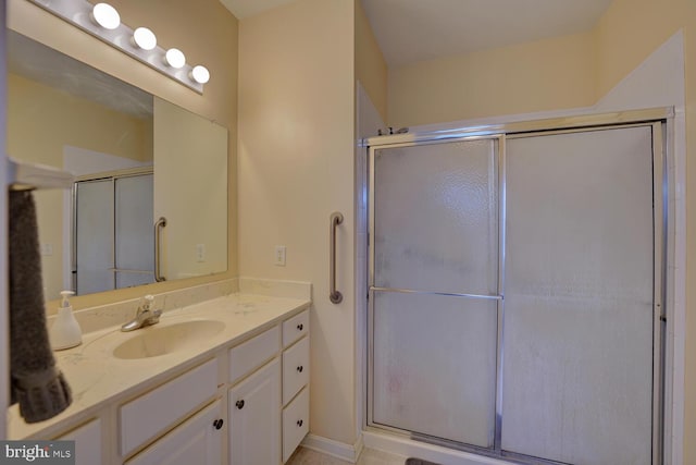 bathroom with vanity and a shower with door