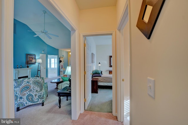 hallway with light carpet and high vaulted ceiling