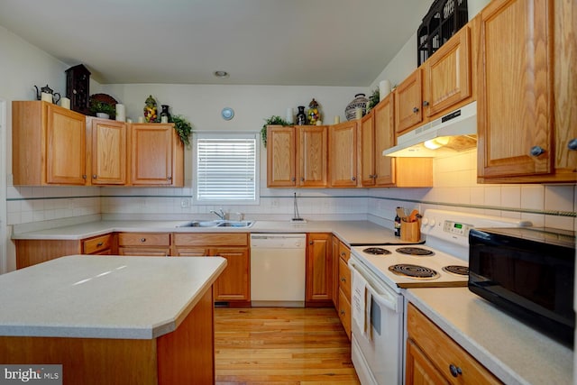 kitchen featuring white appliances, backsplash, light hardwood / wood-style flooring, and sink