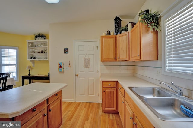 kitchen featuring backsplash, sink, and light wood-type flooring