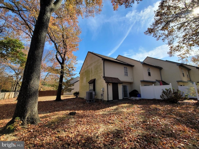 back of property with central AC unit and a garage