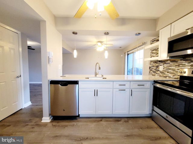 kitchen with backsplash, sink, light hardwood / wood-style floors, white cabinetry, and stainless steel appliances