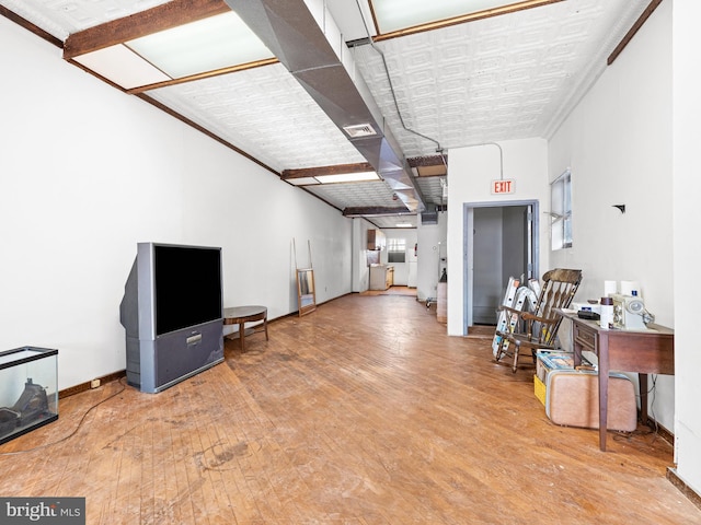 interior space featuring wood-type flooring and ornamental molding