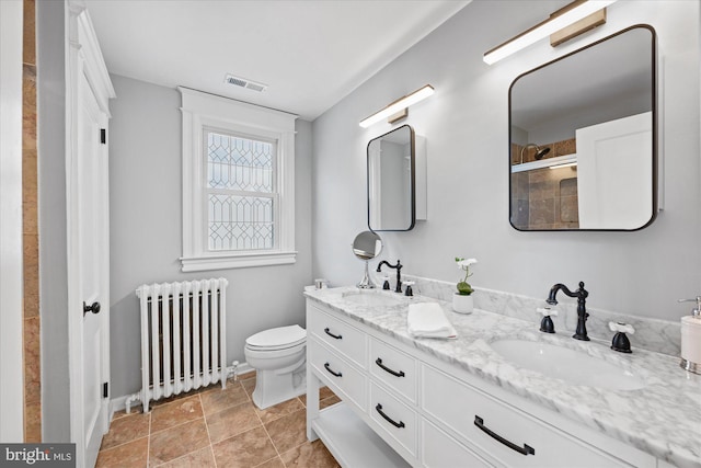 bathroom featuring radiator heating unit, vanity, and toilet