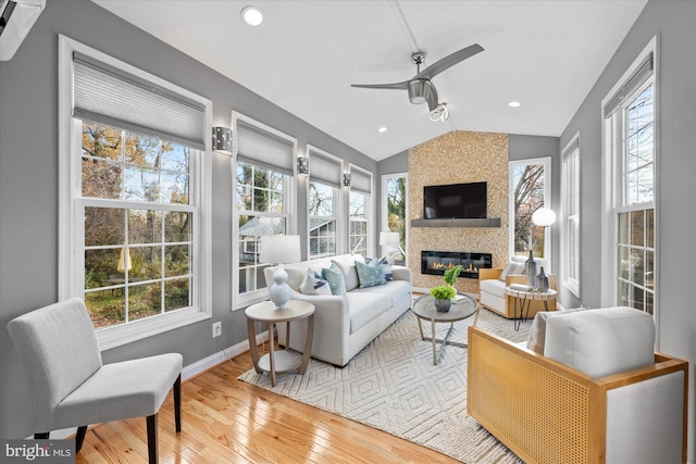 living room with hardwood / wood-style floors, a healthy amount of sunlight, and lofted ceiling