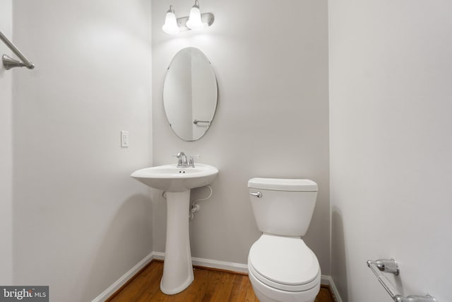 bathroom with wood-type flooring and toilet