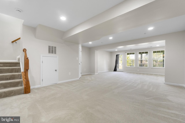 unfurnished living room featuring light colored carpet