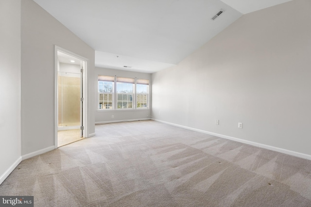 spare room with lofted ceiling and light carpet