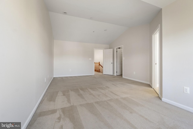 unfurnished bedroom featuring light colored carpet and vaulted ceiling