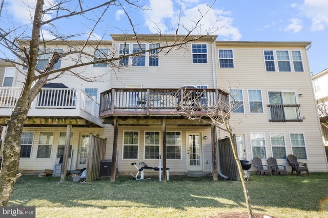 back of property with a deck and a lawn