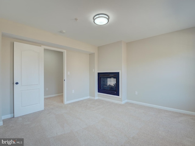 unfurnished living room with a multi sided fireplace and light carpet