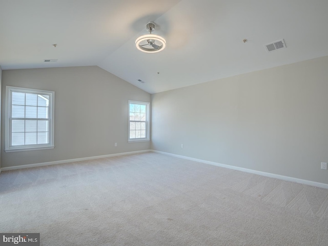 carpeted spare room featuring lofted ceiling