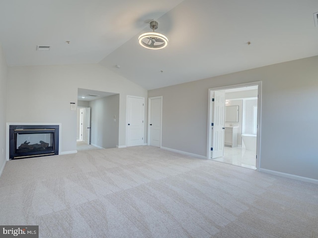 unfurnished living room with light colored carpet and lofted ceiling