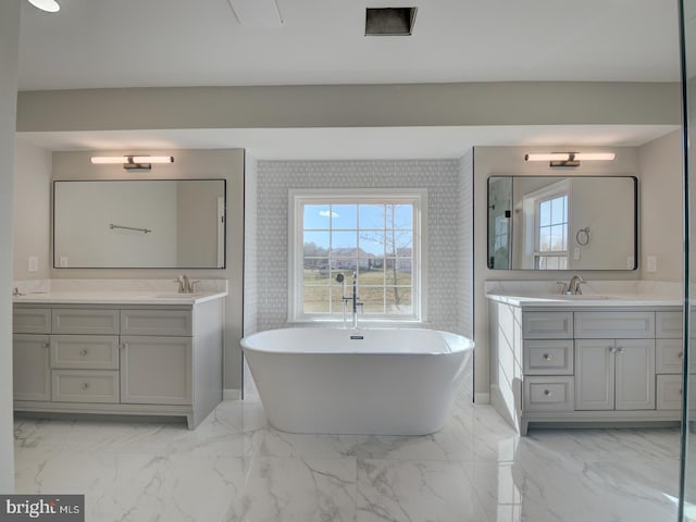 bathroom with a tub to relax in and vanity