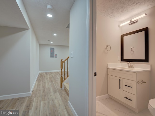 bathroom featuring hardwood / wood-style floors, vanity, a textured ceiling, and toilet