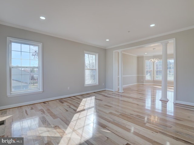 empty room featuring a wealth of natural light, light hardwood / wood-style flooring, and ornamental molding