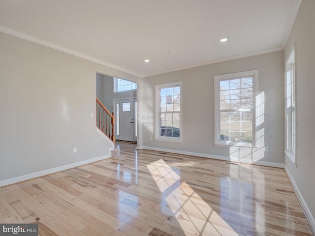 spare room with light wood-type flooring and ornamental molding