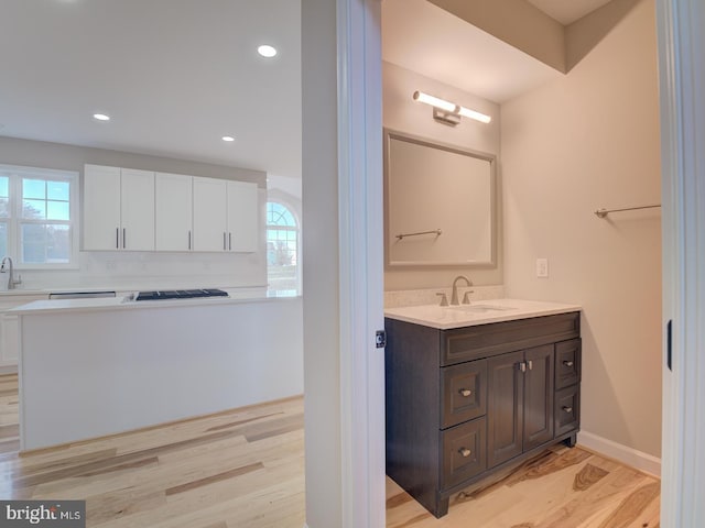 bathroom with hardwood / wood-style floors, vanity, and a healthy amount of sunlight